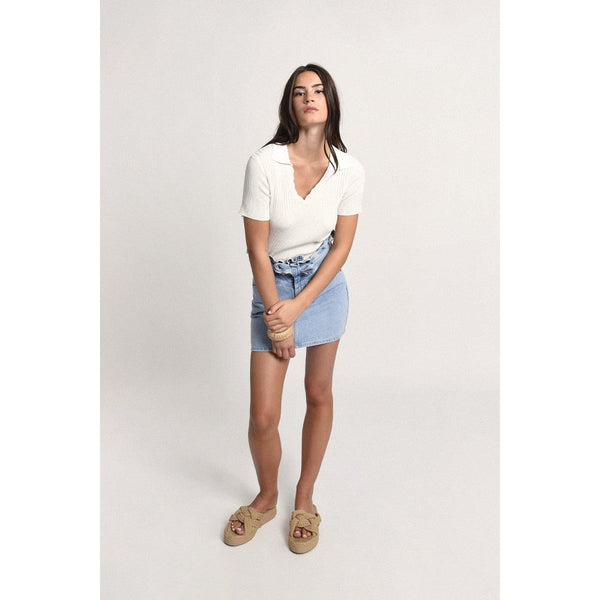 Full body view of the Off White Polo Shirts howing the shirt paired with a denim skirt as one styling option.