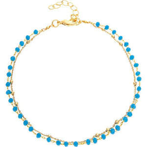 thie view shows how there are two different chains that layer on this anklet; one that is just gold and one that has bright blue beading